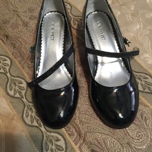 Black patent leather shoes with strap.